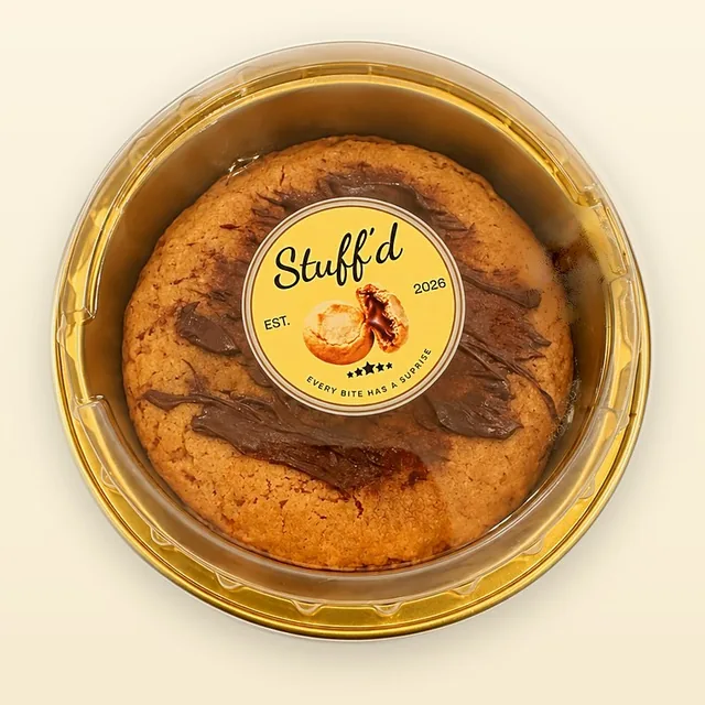 A single Stuff'd cookie sealed in a gold tin with a clear lid and Stuff'd sticker