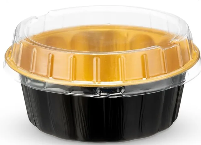 The gold and black tin with its clear dome lid, seen from the side